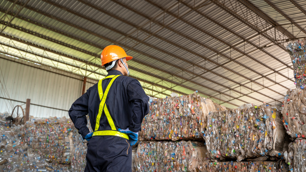 Canadian Foundation Recycles Plastic Waste - Seraphim Plastics - Worker standing infront of bales of plastic recycling
