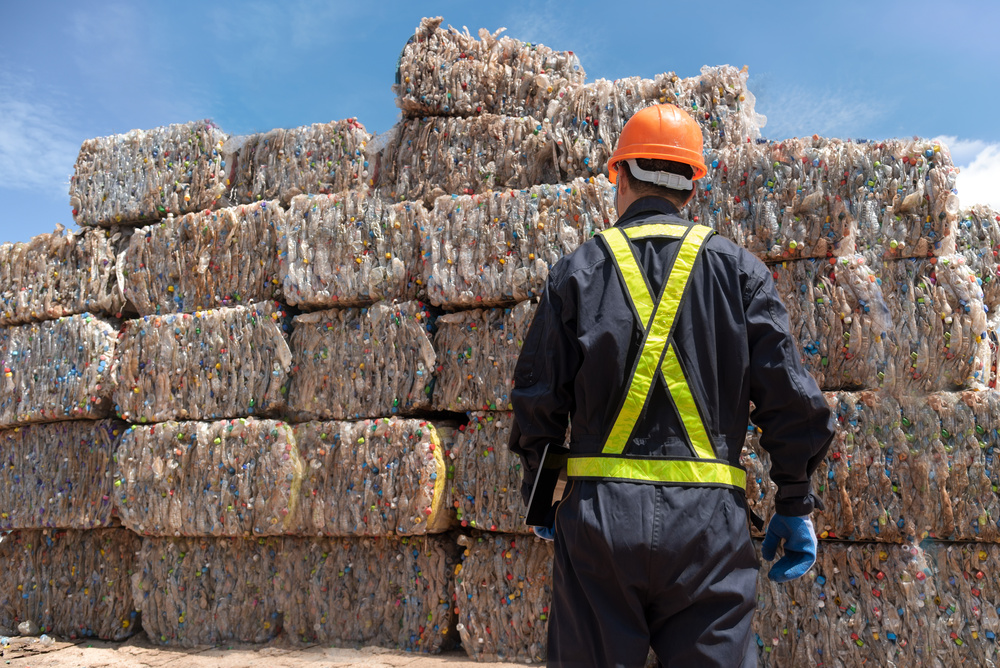 Industrial Plastic Recycling and More in 2023 - Seraphim Plastics - Bales of Plastic Bottles and Worker standing in front with clipboard